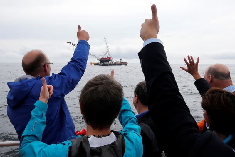 FILE PHOTO: Elected officials and Deepwater Wind executives cheer during a ceremony to mark the installation of the first jacket support structure for a wind farm in the waters of the Atlantic Ocean off Block Island, Rhode Island