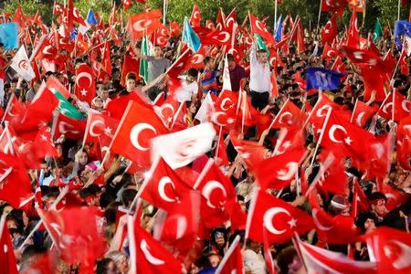 People wave Turkey's national flags as they attend a ceremony marking the first anniversary of the attempted coup in front of the Turkish Parliament in Ankara, Turkey July 16, 2017. REUTERS/Umit Bektas