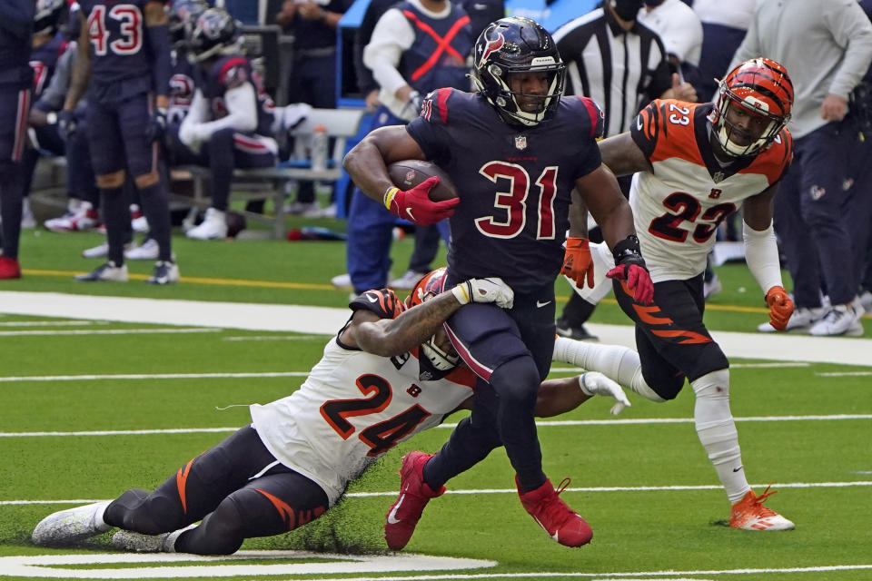 Houston Texans running back David Johnson (31) runs for a first down before being tackled by Cincinnati Bengals strong safety Vonn Bell (24) during the second half of an NFL football game Sunday, Dec. 27, 2020, in Houston. (AP Photo/Eric Christian Smith)