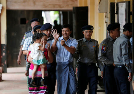 Detained Reuters journalist Kyaw Soe Oo (C) escorted by police and his wife arrives for a court hearing in Yangon, Myanmar April 25, 2018. REUTERS/Stringer