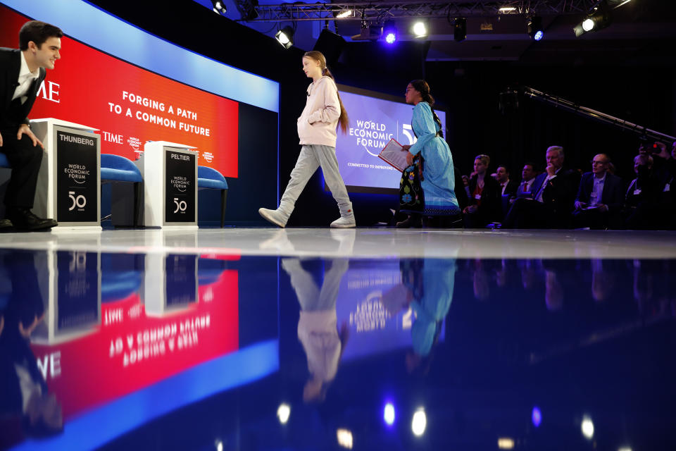 Swedish environmental activist Greta Thunberg, center, Autumn Peltier, Chief Water Commissioner of the Anishinabek Nation, right, and Salvador Gomez-Colon, founder of Light & Hope for Puerto Rico, left, take their seats at the World Economic Forum in Davos, Switzerland, Tuesday, Jan. 21, 2020. The 50th annual meeting of the forum will take place in Davos from Jan. 20 until Jan. 24, 2020. (AP Photo/Markus Schreiber)