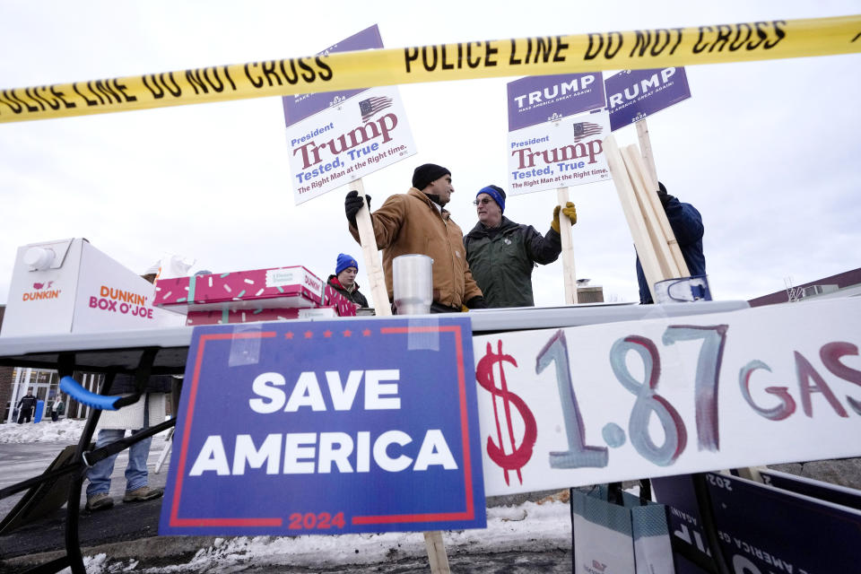 People display signs in support of Republican presidential candidate former President Donald Trump, Tuesday, Jan. 23, 2024, near a polling site at Winnacunnet High School in Hampton, N.H. (AP Photo/Steven Senne)