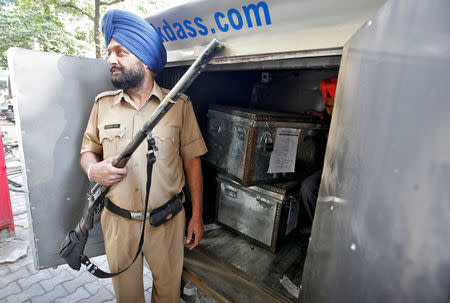 A security guard stands in front of a van carrying Indian currency outside a bank in Chandigarh, November 10, 2016. REUTERS/Ajay Verma