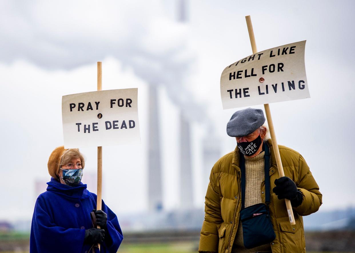 Protesters Barbara Hickey, left, and David Linge attend the Kingston coal ash disaster memorial which memorialized 51 workers who died since the Dec. 22, 2008 spill in Kingston, Tenn., on Sunday, Dec. 20, 2020.