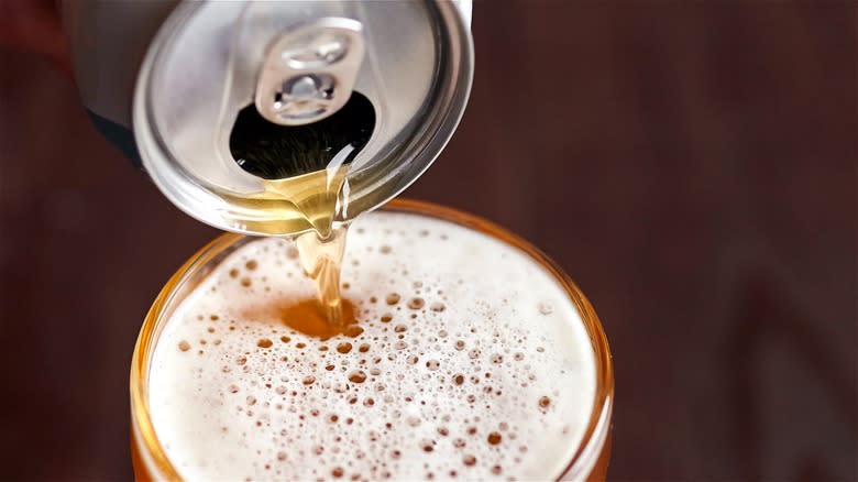Can of beer poured into glass 