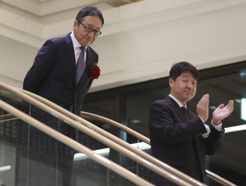 SoftBank Corp.'s CEO Ken Miyauchi, left, arrives at the Tokyo Stock Exchange in Tokyo, Wednesday, Dec. 19, 2018. SoftBank Group Corp.'s Japanese mobile subsidiary began trading on the Tokyo Stock Exchange on Wednesday in one of the world's biggest share offerings. (AP Photo/Koji Sasahara)