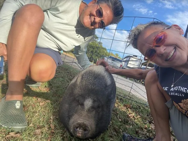 The author and her wife with Minnie Pearl, the pig at Lone Star Bar in Fredericksburg, Texas, in October 2021.