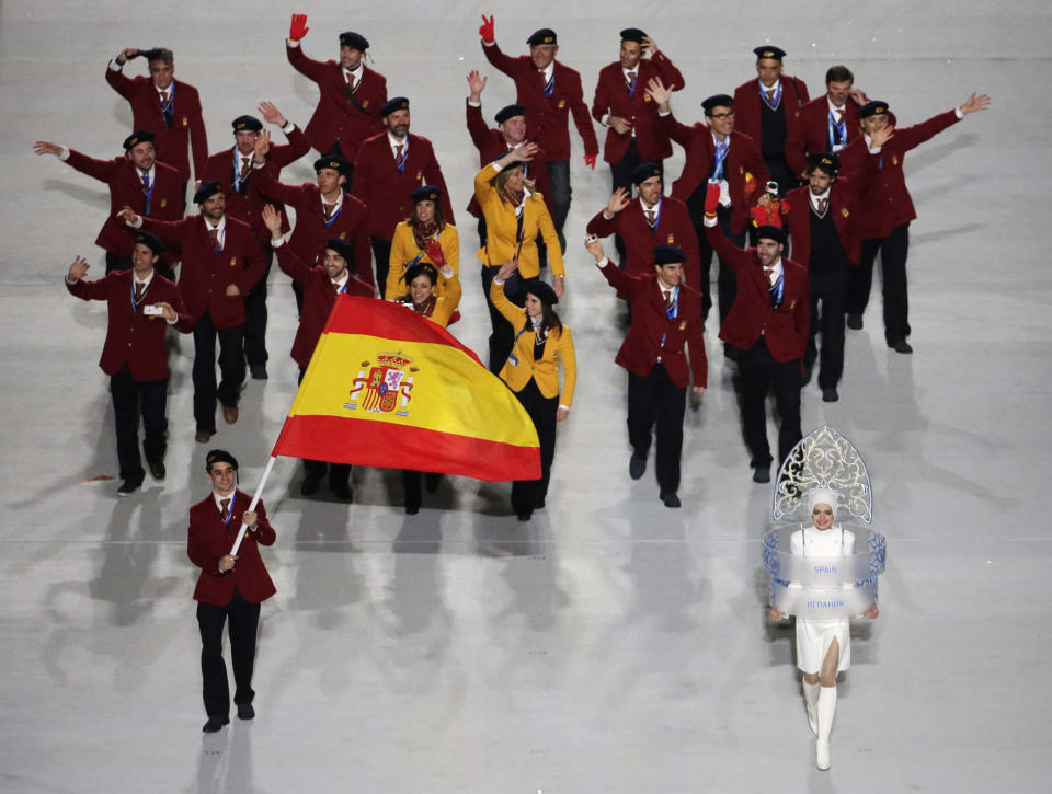 Javier Fernandez of Spain holds the national flag and enters the arena with his teammates during the opening ceremony of the 2014 Winter Olympics in Sochi, Russia, Friday, Feb. 7, 2014. (AP Photo/Charlie Riedel)