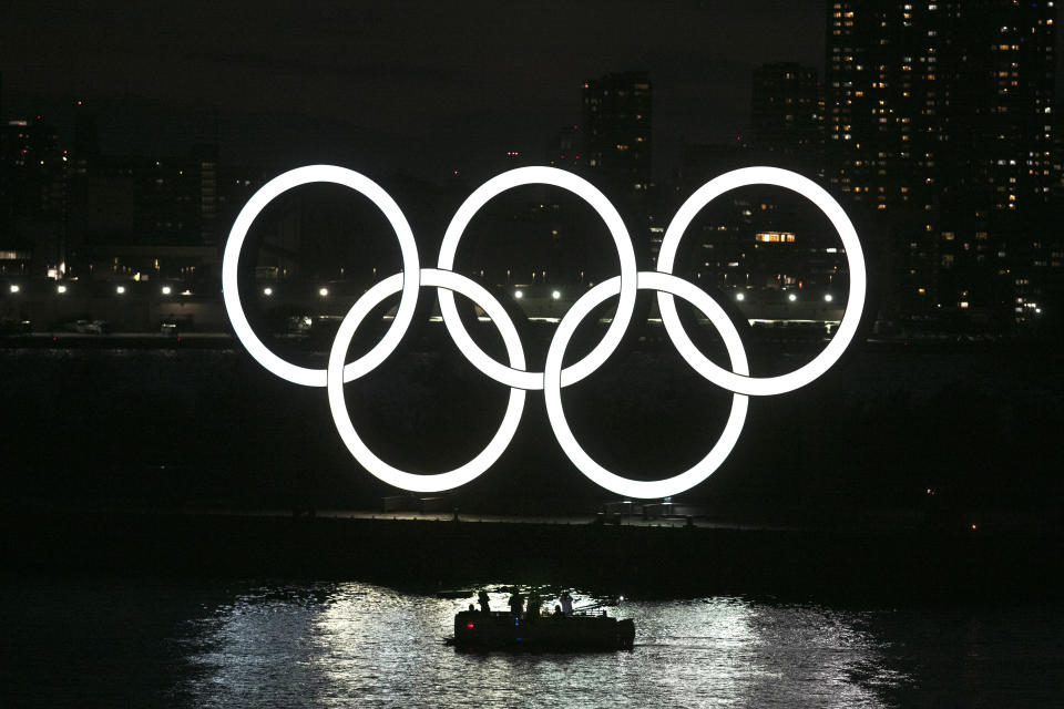 People in a small boat view the Olympic rings in the Odaiba section of Tokyo, Thursday, March 12, 2020. Tokyo Governor Yuriko Koike spoke Thursday after the World Health Organization labeled the spreading virus a "pandemic," a decision almost certain to affect the Tokyo Olympics. (AP Photo/Jae C. Hong)