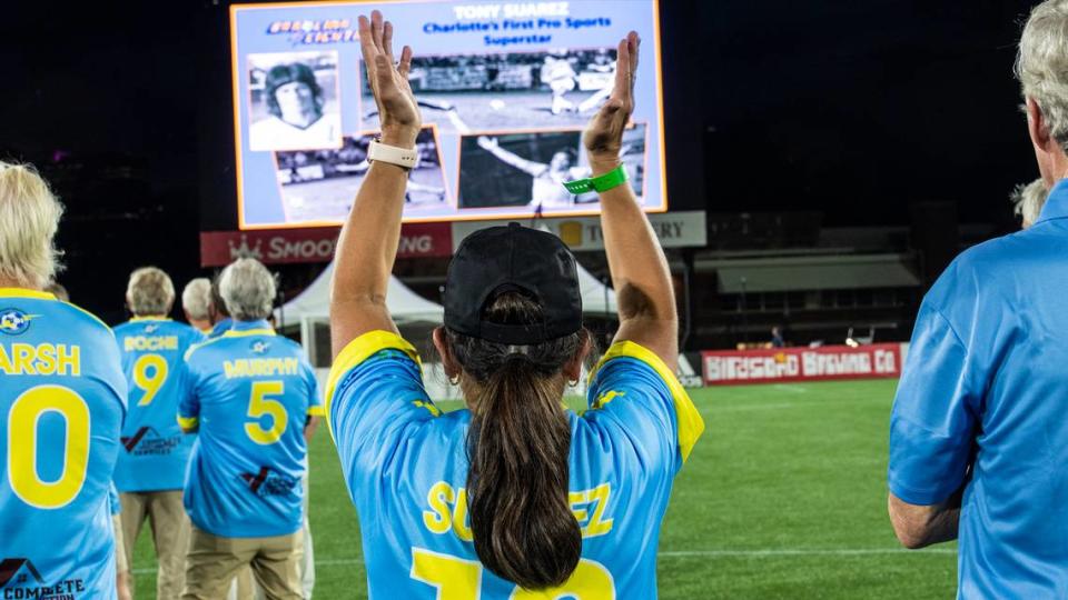 Ana Suarez Fleming, center, youngest sister of the late soccer player Tony Suarez, raises her arms to clap for a tribute on the big screen to her brother during a throwback night at a Charlotte Independence soccer game at American Legion Memorial Stadium on Saturday, September 18, 2021 in Charlotte, NC.