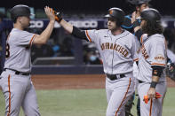 San Francisco Giants' Austin Slater, center, is congratulated by Buster Posey, left, and Brandon Crawford after Slater hit a three-run home run during the seventh inning of the team's baseball game against the Miami Marlins, Saturday, April 17, 2021, in Miami. (AP Photo/Marta Lavandier)