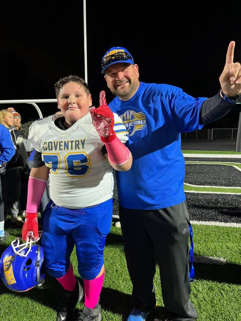 New Coventry High School football head coach Rich Smith, right, smiles with his son, Benjamin Smith, in 2022. Rich coached and Ben played on the Coventry fifth-sixth grade team that topped Field to win the Northeast Ohio Youth Football League championship.