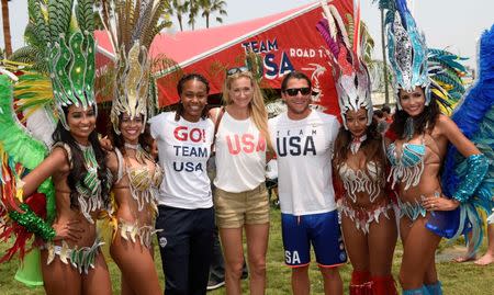 Jul 23, 2016; Los Angeles, CA, USA; American basketball player Tamika Catchings (third from left) and American volleyball player Kerri Walsh-Jennings (center) and American water polo player Tony Azevedo (third from right) pose with samba dancers during the Team USA Road to Rio tour at Venice Beach. Mandatory Credit: Kelvin Kuo-USA TODAY Sports