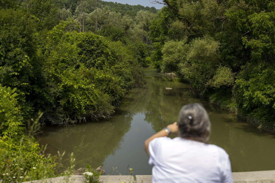 Jeanne Shanendoah talks about the present-day health of Onondaga Creek, Thursday, Aug. 3, 2023, on the Onondaga Nation territory in central New York. "We're deprived of the usage of this water," she said. The waterway, which was once used by the Onondaga for fishing, hunting and swimming, is now muddied with sediment as a result of salt mining. (AP Photo/Lauren Petracca)