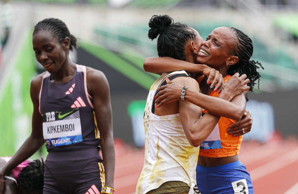 Beatrice Chebet of Kenya, celebrates her world record in the 10,000 with a time of 28:54.14, during the Prefontaine Classic track and field meet Saturday, May 25, 2024, in Eugene, Ore. Gudaf Tsegay, left, of Ethiopia came in second and celebrates with Chebet. (AP Photo/Thomas Boyd)