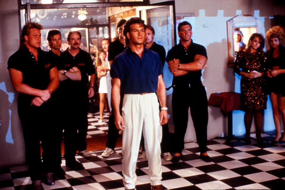 Tough-guy bouncer Dalton (Patrick Swayze, center) sends some ruffians outside in the 1989 action movie "Road House."