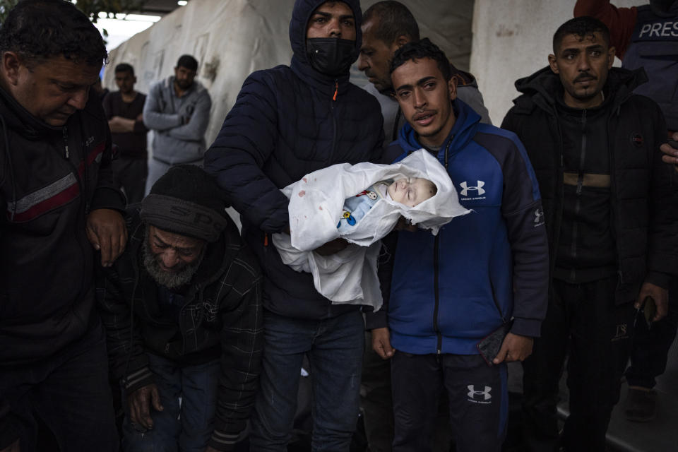 Palestinians mourn a baby killed in the Israeli bombardment of the Gaza Strip at a hospital morgue in Rafah, Monday, Feb. 12, 2024. The Israeli military said early Monday that it had rescued two hostages from captivity in the Gaza Strip. The operation, which was accompanied by airstrikes, killed dozens of Palestinians, according to local health officials. (AP Photo/Fatima Shbair)