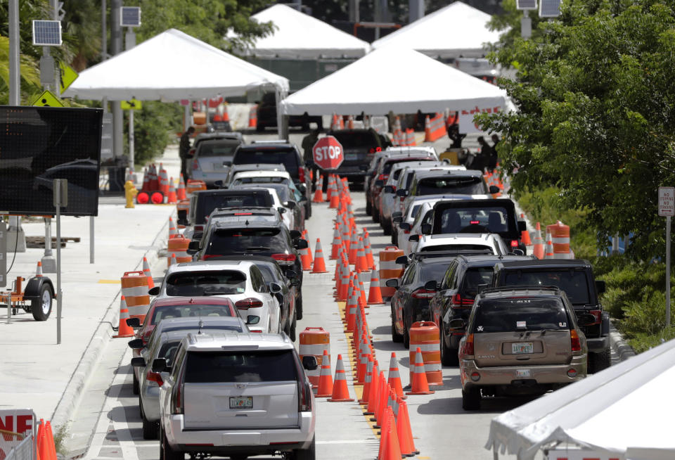 FILE - In this June 26, 2020, file photo lines of cars wait at a drive-through coronavirus testing site outside the Miami Beach Convention Center in Miami Beach, Fla. An Associated Press analysis of coronavirus case data shows the virus has moved, and is spreading quickly, into Republican areas, a new path with broad potential political ramifications. (AP Photo/Wilfredo Lee, File)