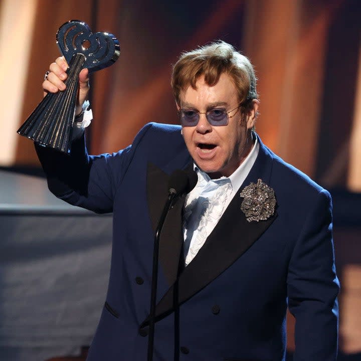 Elton holding an award onstage