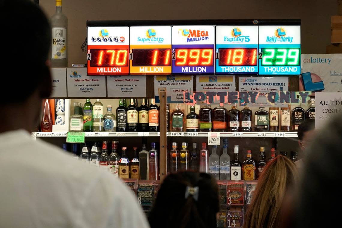 People stand in line to purchase Mega Millions lottery tickets at Lichine’s Liquors & Deli in Sacramento on Friday. The jackpot for the giant Mega Millions lottery jackpot keeps grower larger as officials raise the massive prize to $1.28 billion for Friday’s drawing, beyond the numbers that can be displayed on the sign.