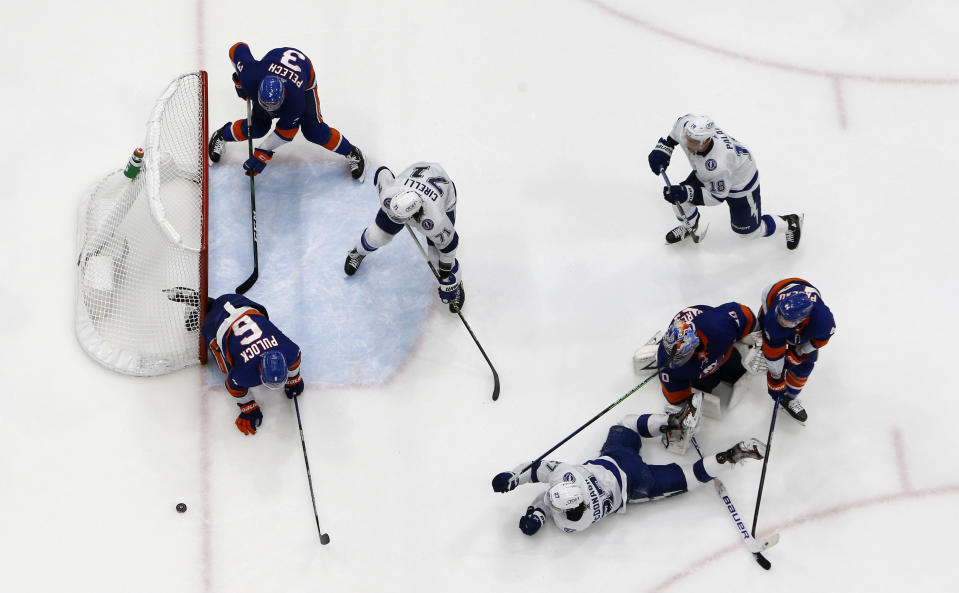 New York Islanders defenseman Ryan Pulock (6) clears the puck from the crease during the final seconds of after a shot from Tampa Bay Lightning defenseman Ryan McDonagh (27) during the third period in Game 4 of an NHL hockey Stanley Cup semifinal, Saturday, June 19, 2021, in Uniondale, N.Y. (AP Photo/Jim McIsaac)