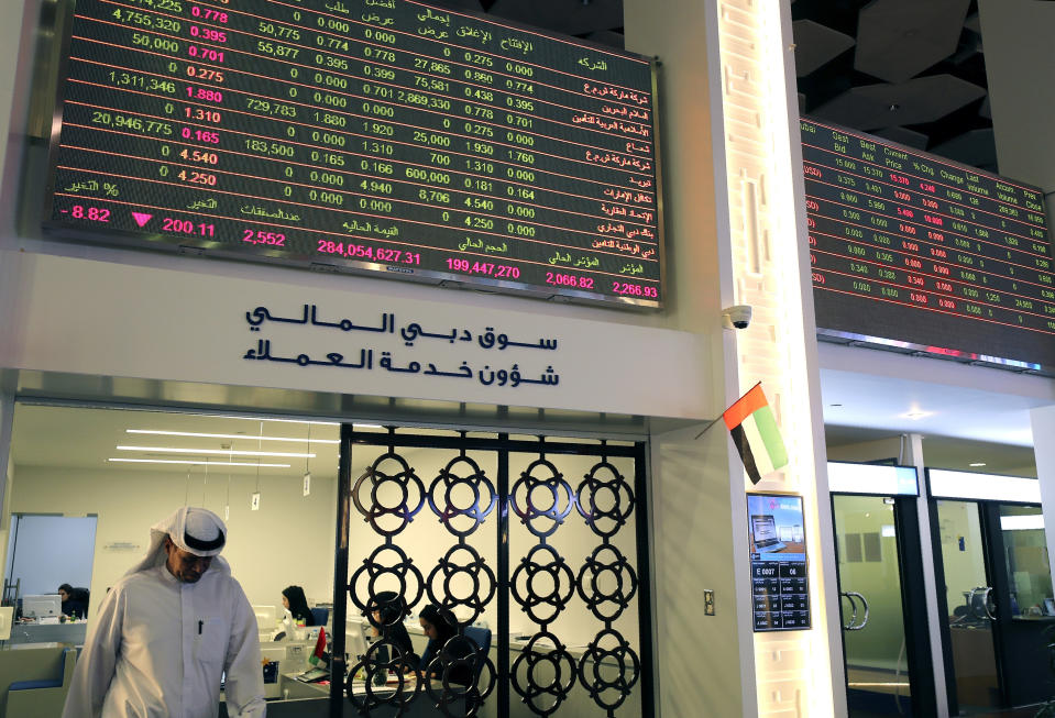 An Emirati trader leaves an office at the Dubai Financial Market in Dubai, United Arab Emirates, Monday, March 9, 2020. Saudi Arabia closed off air and sea travel to nine countries affected by the new coronavirus Monday as Mideast stock markets tumbled over fears about the widening outbreak's effect on the global economy. (AP Photo/Kamran Jebreili)