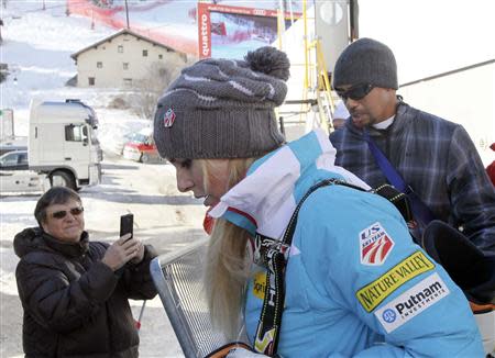 Lindsey Vonn (C) of the U.S. and her boyfriend Tiger Woods leave after the Women's World Cup Downhill skiing race in Val d'Isere, French Alps, December 21, 2013. REUTERS/Robert Pratta