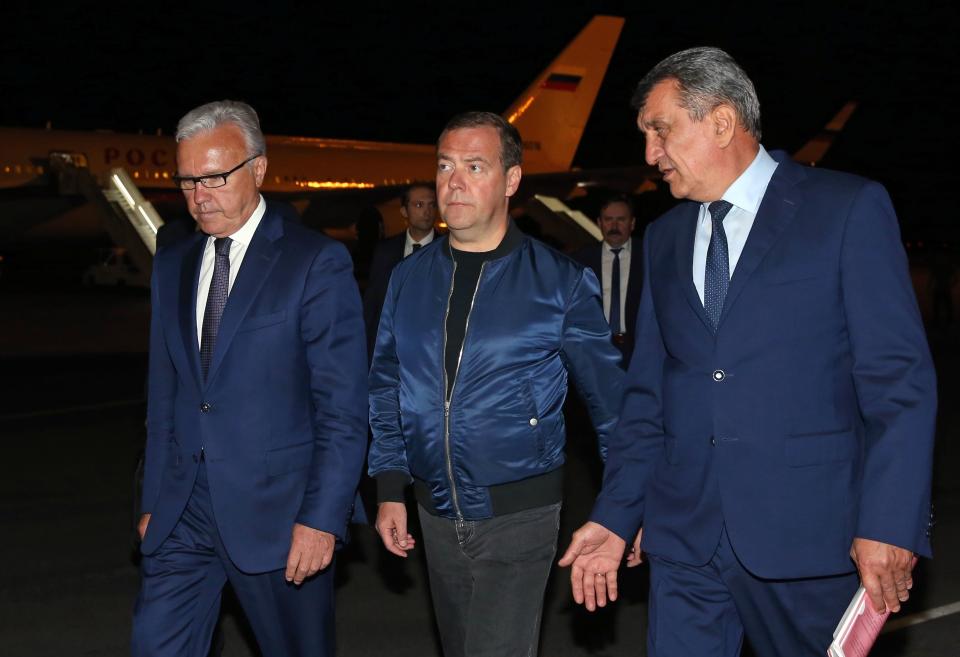 Russian Prime Minister Dmitry Medvedev, center, walks with a presidential envoy in the Siberian region Sergey Menyaylo, right, and governor of Krasnoyarsk Region Alexander Uss upon his arrival at the airport near Krasnoyarsk, Russia, Wednesday, July 31, 2019. Russian President Vladimir Putin has ordered Russia's military to join efforts to fight forest fires that have engulfed nearly 30,000 square kilometers (11,580 sq. miles) of territory in Siberia and the Russian Far East. (Yekaterina Shtukina, Sputnik, Government Pool Photo via AP)
