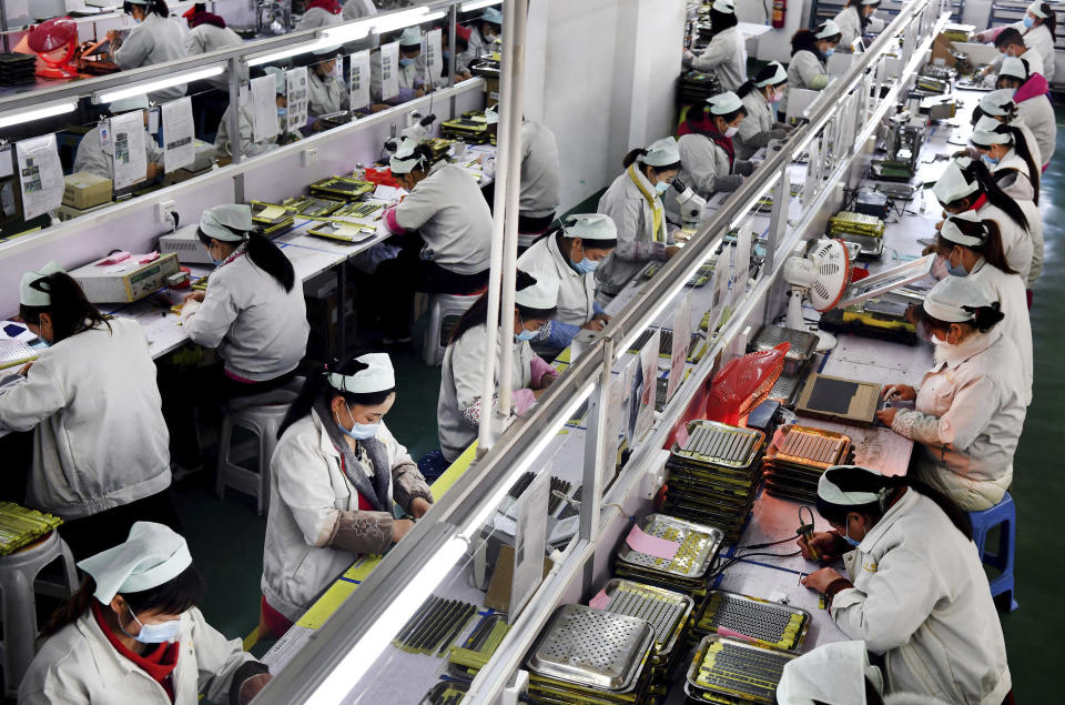 In this March 4, 2020, photo released by Xinhua News Agency, workers wearing mask labor in an electronic technology company in Mianxian County, northwestern China's Shaanxi province. Factories in China that make the world's smartphones, toys and other consumer goods are trying to protect their employees from a virus outbreak as they resume production. Manufacturers are buying masks by the thousands and jugs of disinfectant. The ruling Communist Party has told local officials to help reopen factories that were idled by the most intensive anti-disease controls ever imposed.(Tao Ming/Xinhua via AP)