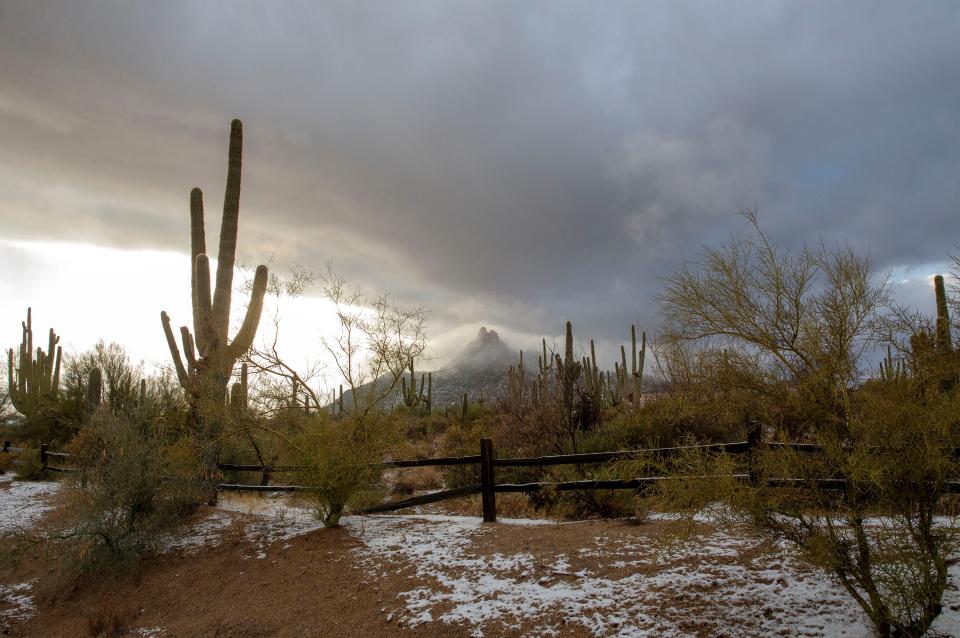Snow and clouds create a winter scene on Pinnacle Peak at the Reata Pass in Scottsdale. A winter storm brought rain, sleet and snow to central Arizona on Jan. 25, 2021.