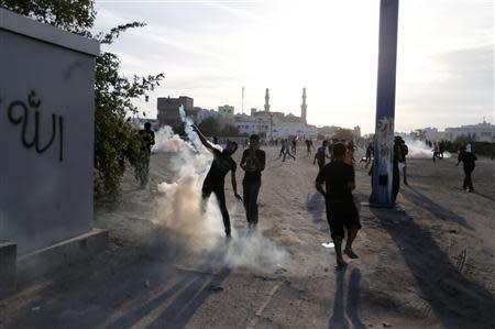 An anti-government protester throws a tear gas canister during clashes after a revisit to the grave of detainee Jaffar Mohammed, in the village of Daih west of Manama, March 3, 2014. REUTERS/Hamad I Mohammed