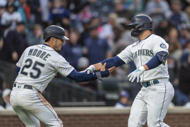 Seattle Mariners' Eugenio Suarez, right, is congratulated by Sam