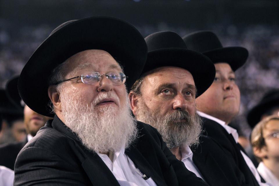 Orthodox Jewish men sit at MetLife stadium in East Rutherford, N.J, Wednesday, Aug. 1, 2012, during the celebration Siyum HaShas. The Siyum HaShas, marks the completion of the Daf Yomi, or daily reading and study of one page of the 2,711 page book. The cycle takes about 7½ years to finish.This is the 12th put on by Agudath Israel of America, an Orthodox Jewish organization based in New York. Organizers say this year's will be, by far, the largest one yet. More than 90,000 tickets have been sold, and faithful will gather at about 100 locations worldwide to watch the celebration. (AP Photo/Mel Evans)