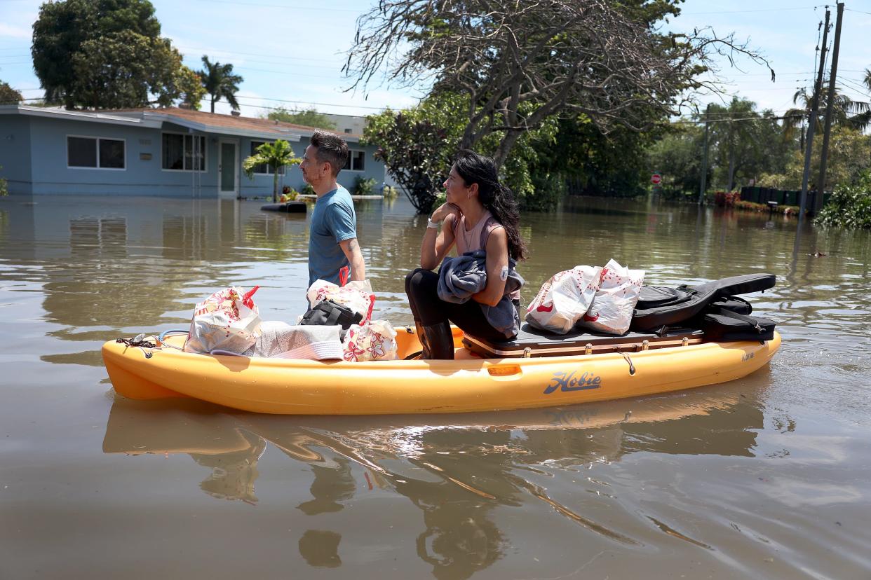 Maggie Hernandez rides on a kayak as she salvages what she can from her home that was inundated with flood water on April 14, 2023, in Fort Lauderdale, Florida. Nearly 26 inches of rain fell on Fort Lauderdale over a 24-hour period causing flooding.