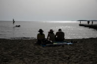 FILE - In this file photo dated Tuesday, June 22, 2021, people on a beach of Kavouri near Athens, Greece. There is guarded optimism about tourists returning in 2021, and according to the World Travel and Tourism Council, international travel is key to economic recovery for countries like Greece and Italy that rely more heavily on it. (AP Photo/Yorgos Karahalis)