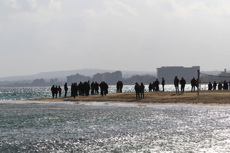 FILE PHOTO: People stand against the background of Varosha, an area fenced off by the Turkish military since the 1974 division of Cyprus, during a celebration for Orthodox Epiphany Day for the fifth time in decades, in Famagusta