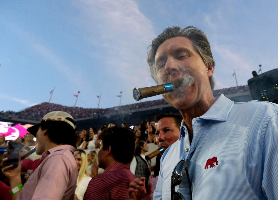 Daven Cave from Mobile lights up a cigar to celebrate at Bryant-Denny Stadium. Alabama defeated Tennessee 34-20 on Oct. 21, 2023.