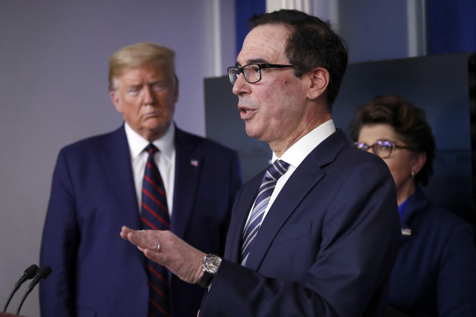 FILe - In this April 2, 2020, file photo, President Donald Trump and Jovita Carranza, administrator of the Small Business Administration, listen as Treasury Secretary Steven Mnuchin speaks about the coronavirus in the James Brady Press Briefing Room of the White House in Washington. Hundreds of cities and counties grappling with the economic fallout caused by the pandemic might receive little, if any, of the emergency funding allotted for state and local governments in the $2.2 trillion coronavirus stimulus package.  (AP Photo/Alex Brandon, File)