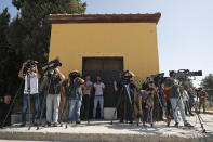 Residents look on as members of the media work at the border between Turkey and Syria, in Akcakale, Sanliurfa province, southeastern Turkey, Tuesday, Oct. 8, 2019. Turkey's vice president Fuat Oktay says his country won't bow to threats in an apparent response to U.S. President Donald Trump's warning to Ankara about the scope of its planned military incursion into Syria. (AP Photo/Lefteris Pitarakis)