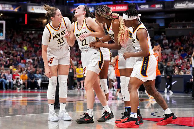 <p>Emilee Chinn/Getty</p> Teammates help Caitlin Clark (second from left) off the court