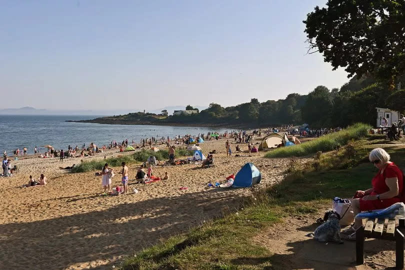 People enjoy the hot, sunny weather on Silver Sands beach.