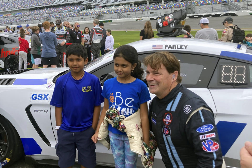 Ford CEO Jim Farley posing with fans on at Daytona International Speedway, Saturday, Jan. 21, 2023, in Daytona Beach, Fla., ahead of the IMSA Vo Racing SportsCar Challenge motor race. It was the professional racing debut for the 60-year-old chief executive of Ford Motor Co. He finished 12th. (AP Photo/Jenna Fryer)