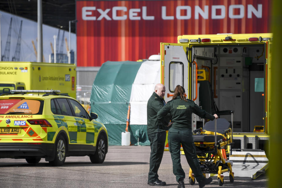 Ambulance staff at the ExCel Center in London, Thursday, April 2, 2020, that is being turned into a 4000 bed temporary hospital know as NHS Nightingale to help deal with some of the coronavirus outbreak victims in London. The new coronavirus causes mild or moderate symptoms for most people, but for some, especially older adults and people with existing health problems, it can cause more severe illness or death. (AP Photo/Alberto Pezzali)