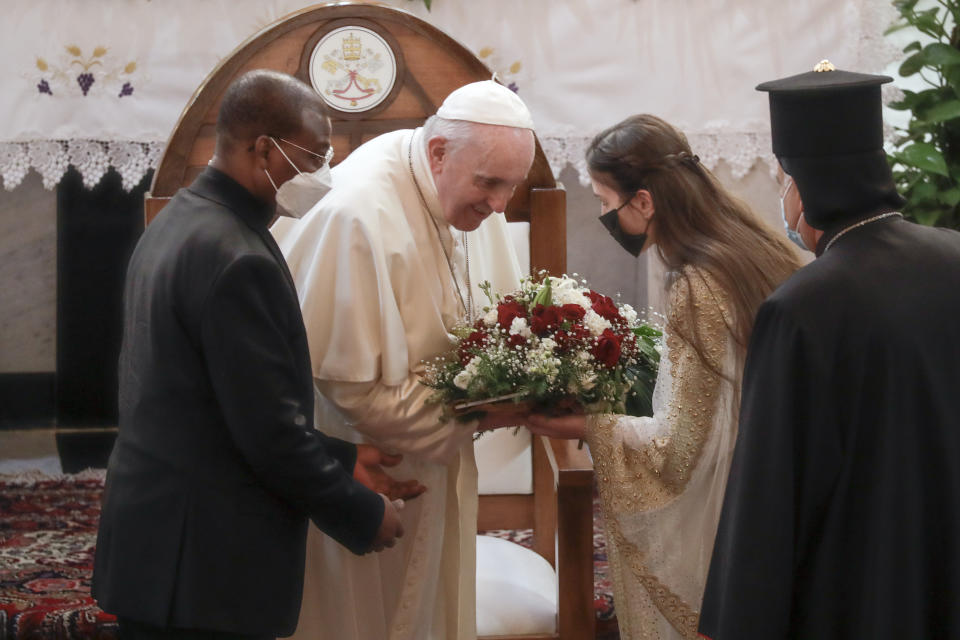 Pope Francis is welcomed upon his arrival at the Sayidat al-Nejat (Our Lady of Salvation) Cathedral, in Baghdad, Iraq, Friday, March 5, 2021. Pope Francis has arrived in Iraq to urge the country's dwindling number of Christians to stay put and help rebuild the country after years of war and persecution, brushing aside the coronavirus pandemic and security concerns. (AP Photo/Andrew Medichini)