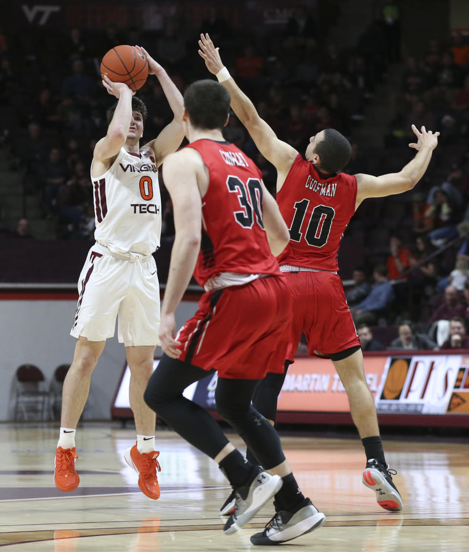 Viginia Tech's Hunter Cattoor (0) shoots a three-point basket and is fouled while defended by Virginia Military Institute's Kamdyn Curfman (10) and Sean Conway (30) in the second half of an NCAA college basketball game Saturday, Dec. 21 2019, in Blacksburg, Va. (Matt Gentry/The Roanoke Times via AP)