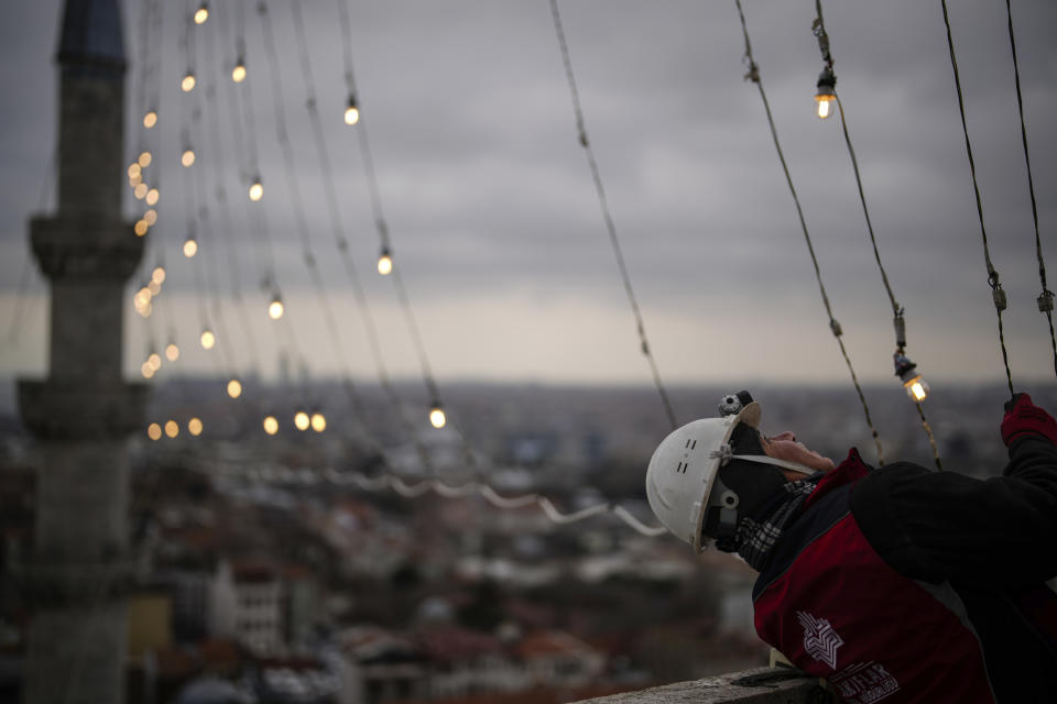 Mahya master Cemil Buyurkan works in the installation of a lights message at the top of one of the minarets of the Suleymaniye mosque ahead of the Muslim holy month of Ramadan, in Istanbul, Turkey, Wednesday, March 6, 2024. Mahya is the unique Turkish tradition of stringing religious messages and designs between minarets. (AP Photo/Emrah Gurel)