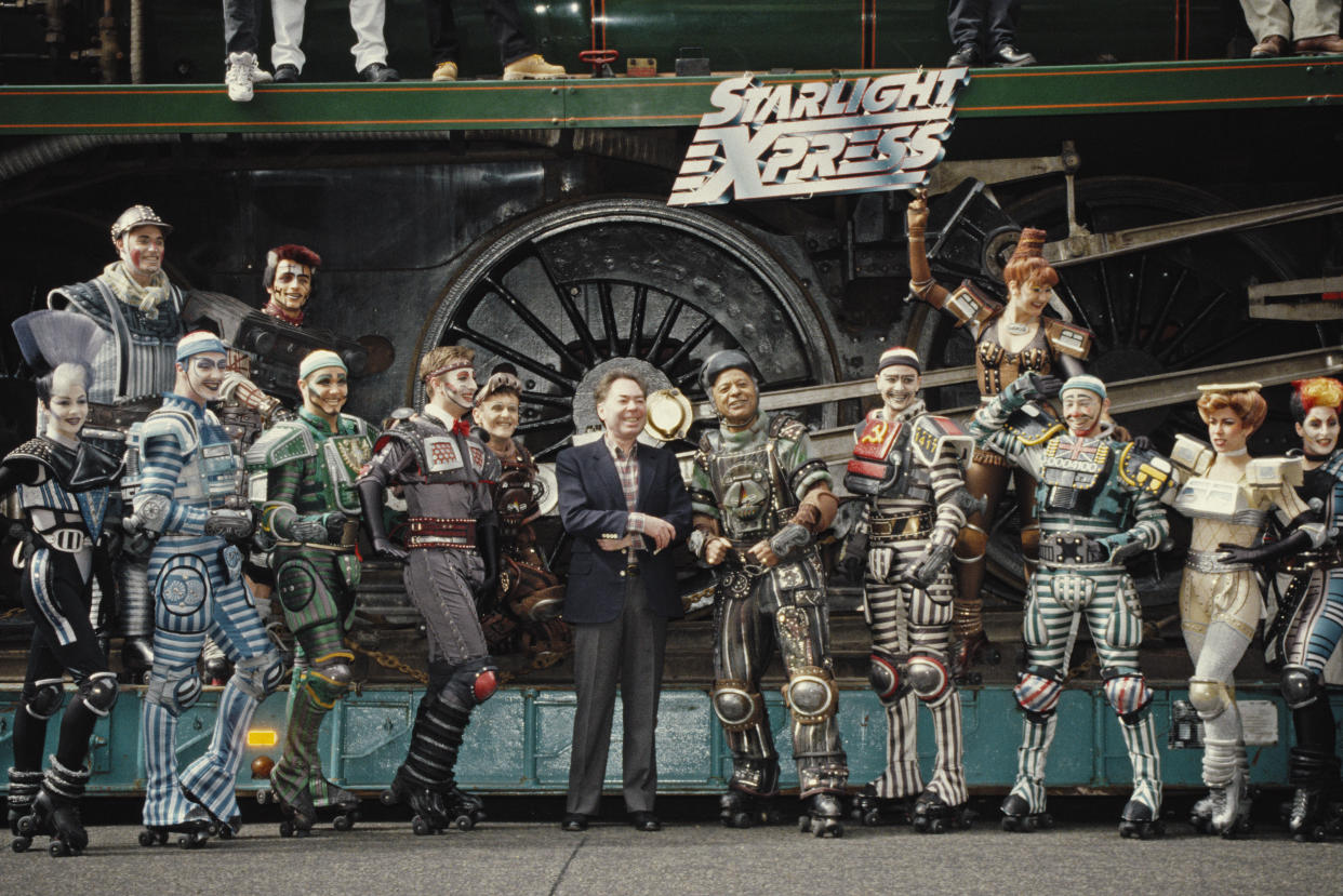 English composer Andrew Lloyd Webber pictured in centre with the cast of his West End stage musical 'Starlight Express', circa 1984. (Photo by Larry Ellis Collection/Getty Images)