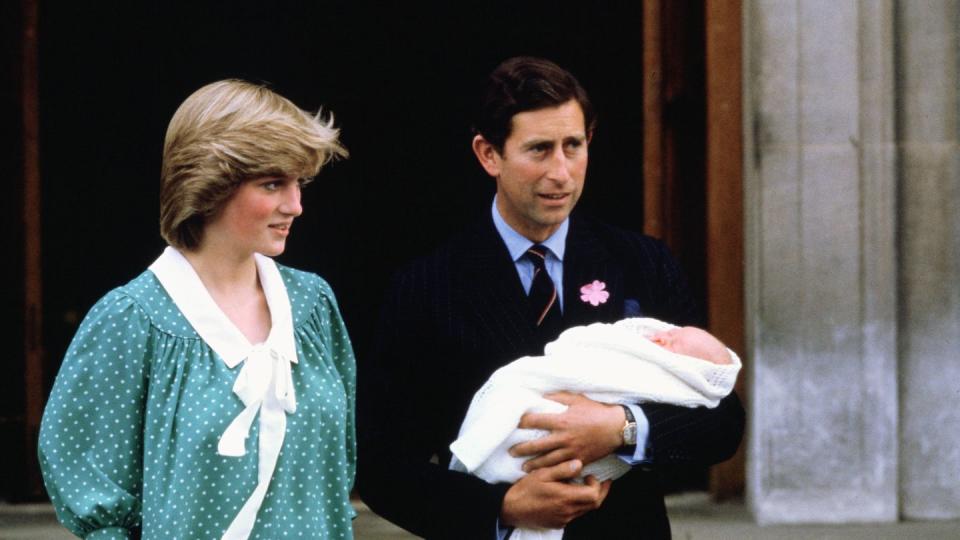 princess diana and prince charles, who holds newborn prince william, stand outside a building