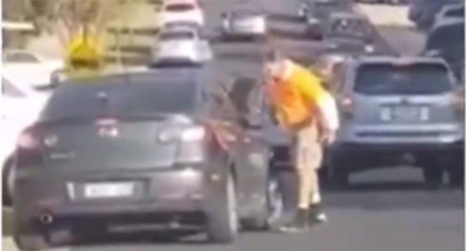 A man confronts the driver of a Mazda, parked at a No Standing zone, near a Mill Park school. Source: 7 News