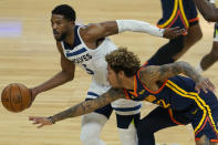 Golden State Warriors guard Kelly Oubre Jr., bottom, reaches for the ball next to Minnesota Timberwolves guard Malik Beasley during the first half of an NBA basketball game in San Francisco, Monday, Jan. 25, 2021. (AP Photo/Jeff Chiu)